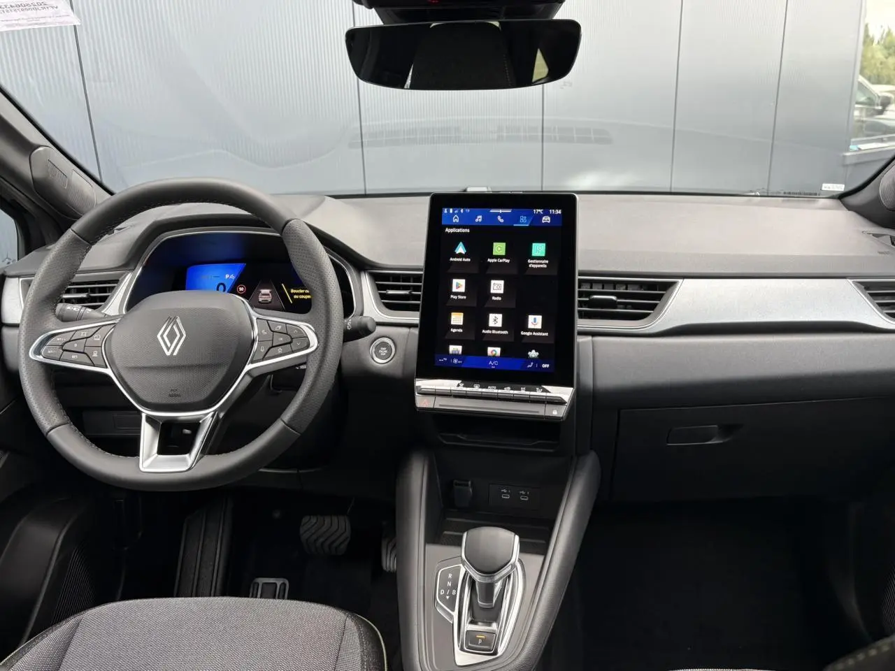 Intérieur Renault SYMBIOZ noir étoile, vue avant centrée sur tableau de bord avec écran tactile vertical et volant multifonction.