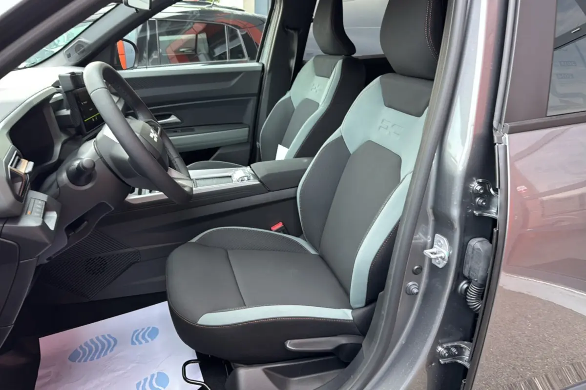 Vue intérieure côté conducteur du Dacia Bigster gris schiste, avec sièges bicolores et volant cuir soft feel.