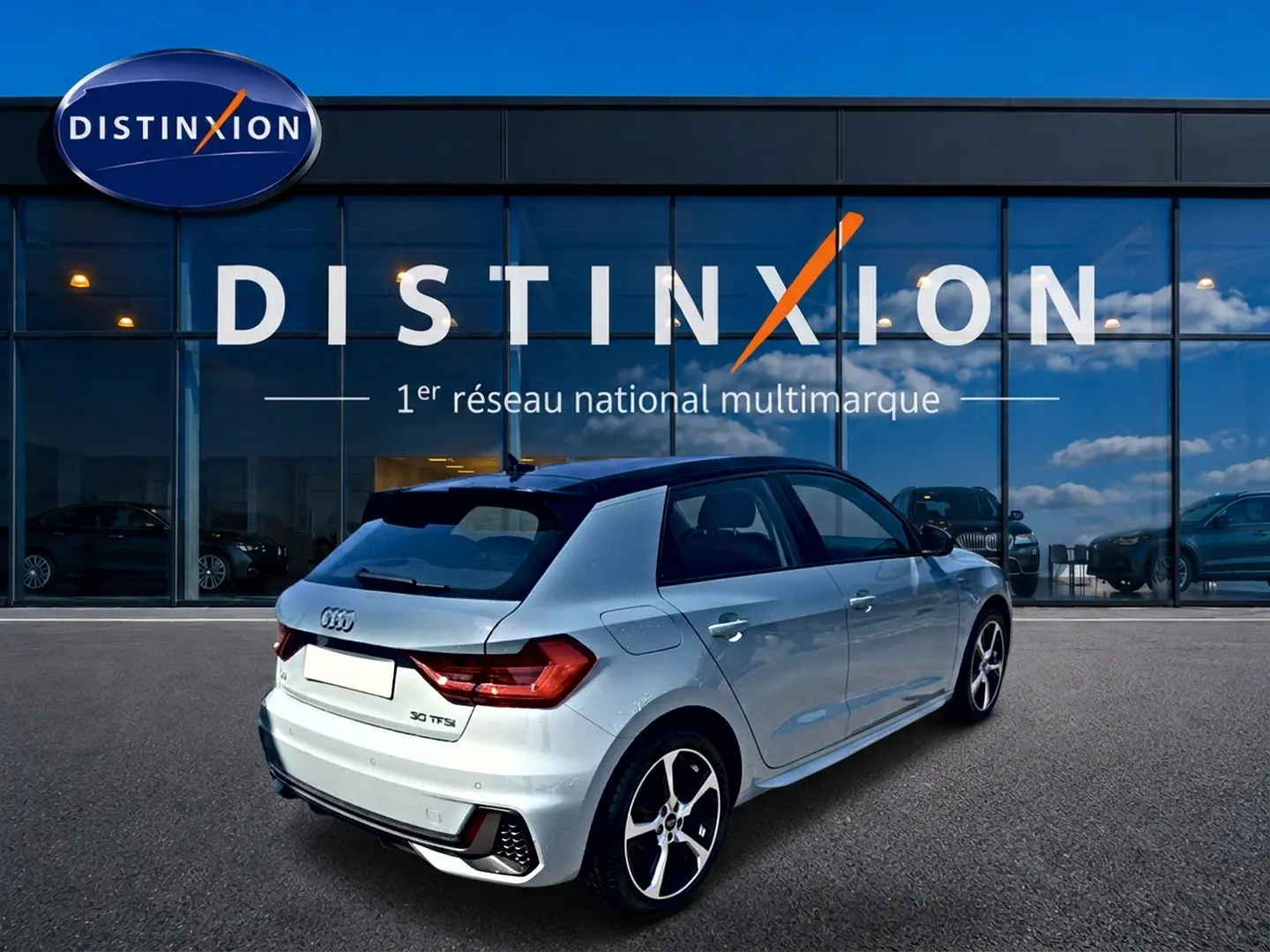 Audi A1 Sportback 30 TFSI gris arrow avec toit noir, vue 3/4 arrière mettant en valeur le becquet et les jantes alu.