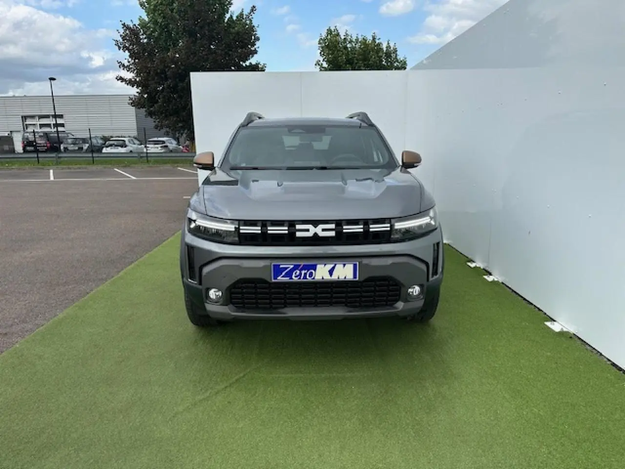 Vue frontale du Dacia Duster III gris schiste métal, avec calandre noire et phares LED étirés.