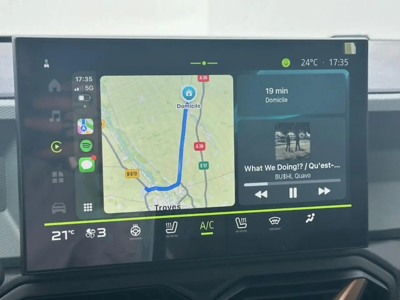 Écran tactile central du Dacia Duster III gris schiste, affichant navigation et musique en intérieur jour.