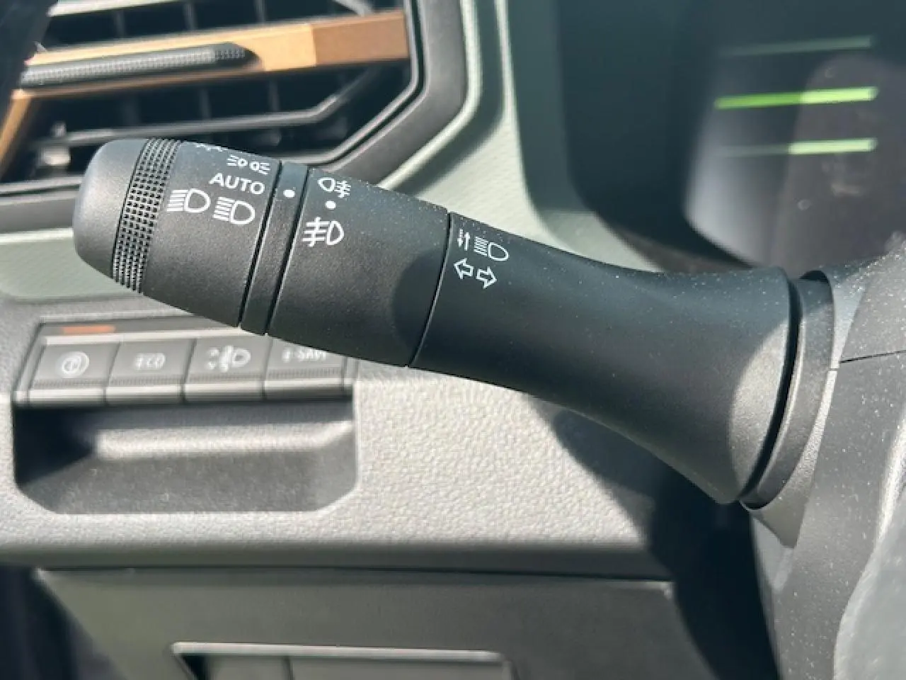 Gros plan sur la commande des feux et clignotants à gauche du volant du Dacia Duster gris schiste 2025.