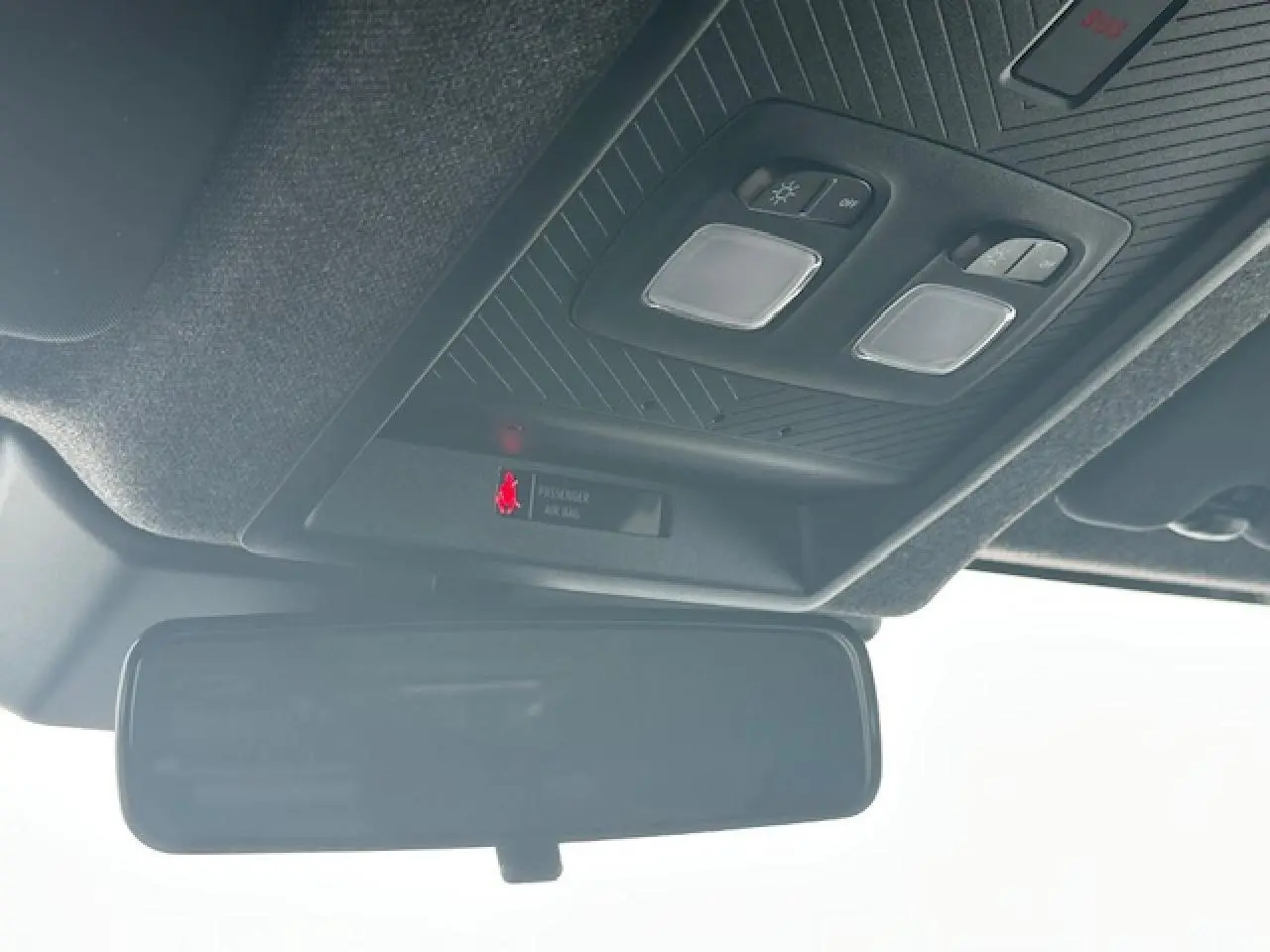 Vue en contre-plongée du plafonnier noir et du rétroviseur intérieur du Dacia Duster gris schiste 2025.