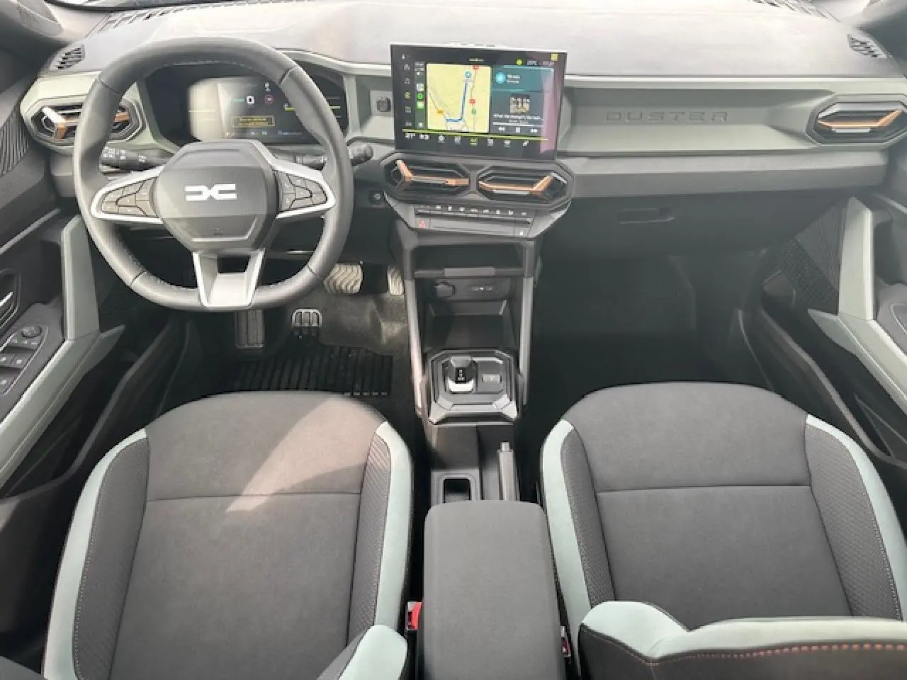 Intérieur du Dacia Duster III 1.6 Hybrid 140, vue de dessus sur tableau de bord digital et sièges TEP MicroCloud.