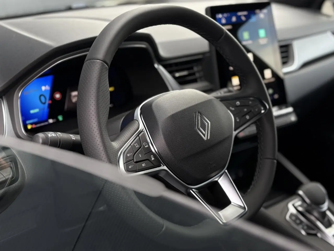 Vue rapprochée du volant en cuir noir de la Renault SYMBIOZ 2025 avec tableau de bord numérique et écran tactile central.