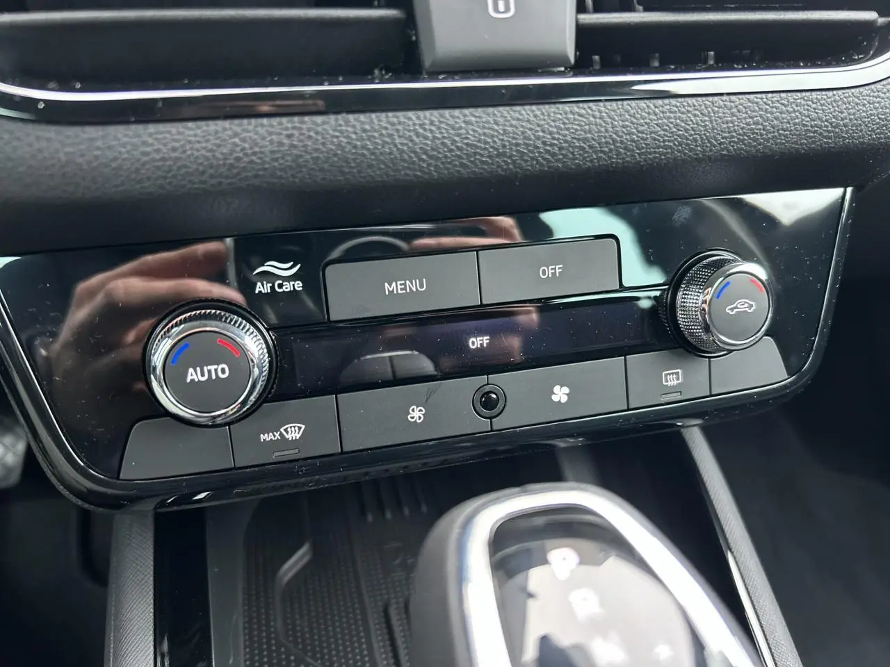 Gros plan sur la console centrale du Skoda Kamiq noir, montrant la climatisation automatique et le levier de boîte automatique.
