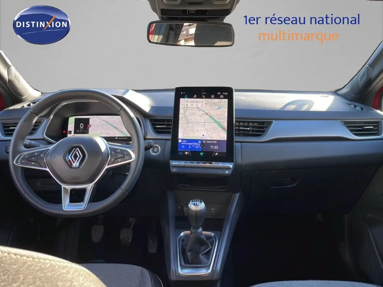 Vue intérieure frontale du tableau de bord du Renault Captur rouge Désir Métal avec écran tactile vertical et volant multifonction.