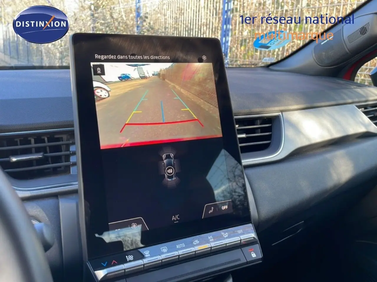 Vue intérieure centrée sur l'écran tactile affichant la caméra de recul du Renault Captur rouge Désir Métal avec toit noir.