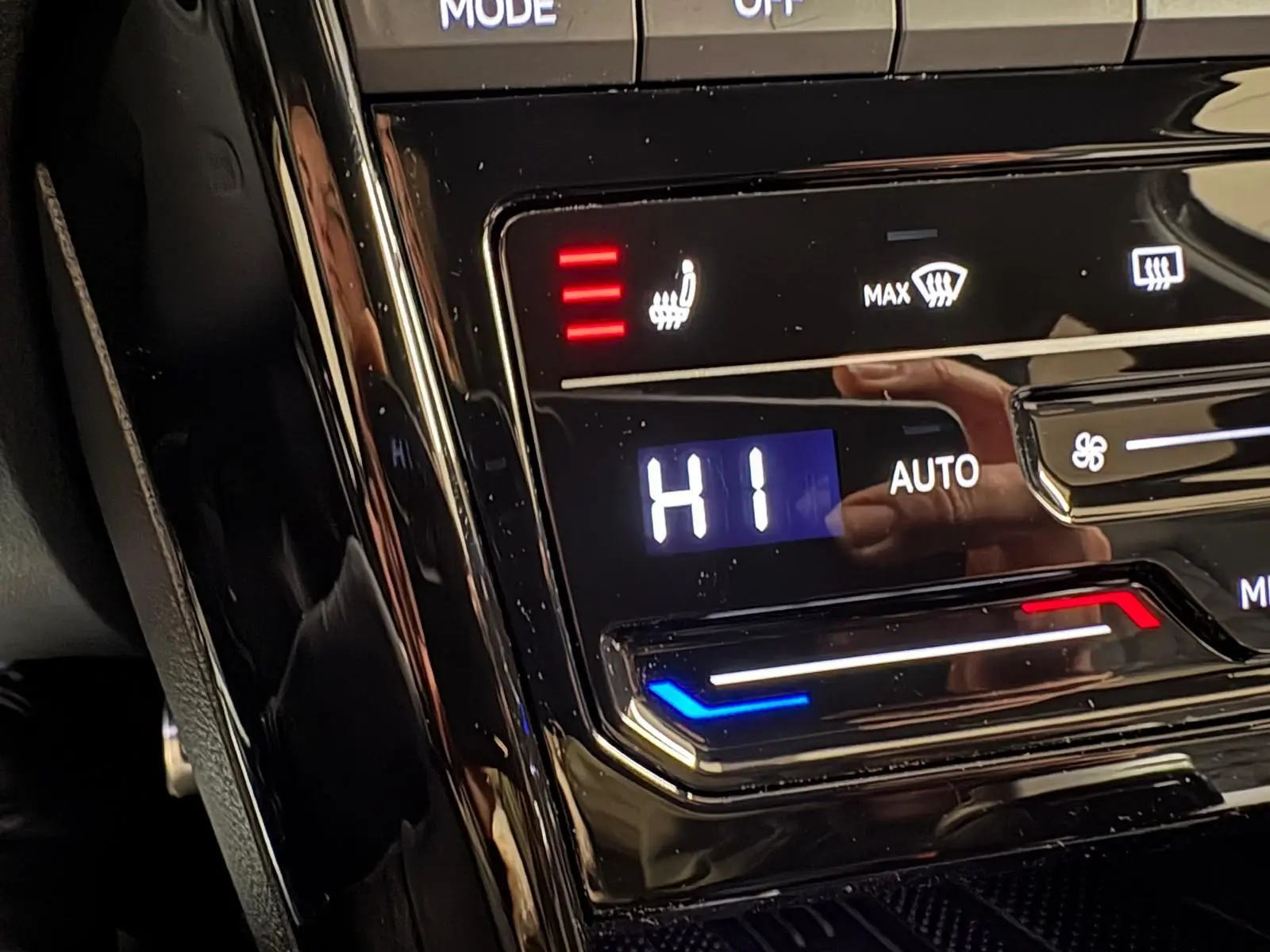 Gros plan sur la commande de climatisation chauffante du Volkswagen T-Roc noir intense, affichant le réglage "HI".