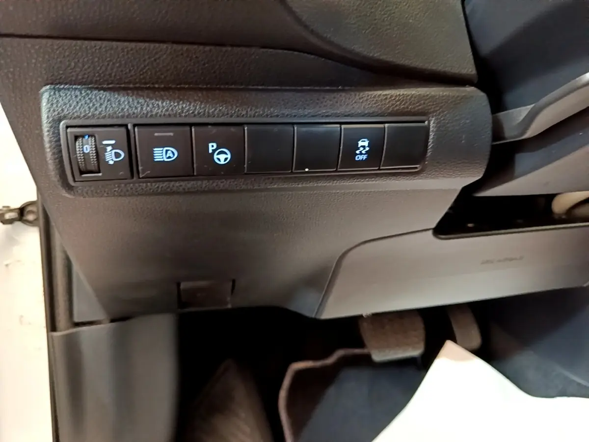 Vue intérieure côté conducteur de la Toyota Corolla hybride blanche 2022, panneau de commandes des aides à la conduite.