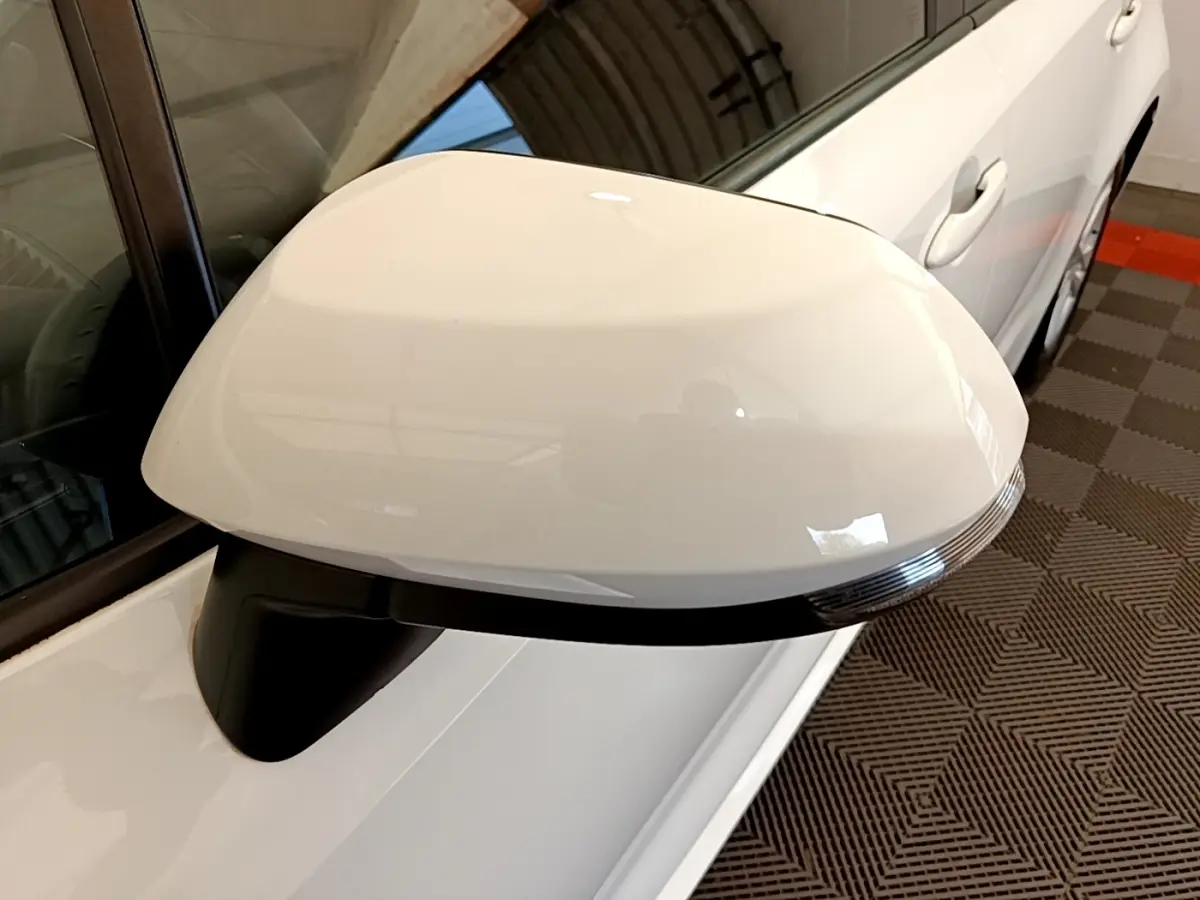 Gros plan sur le rétroviseur droit blanc de la Toyota Corolla hybride 2022, avec clignotant intégré.