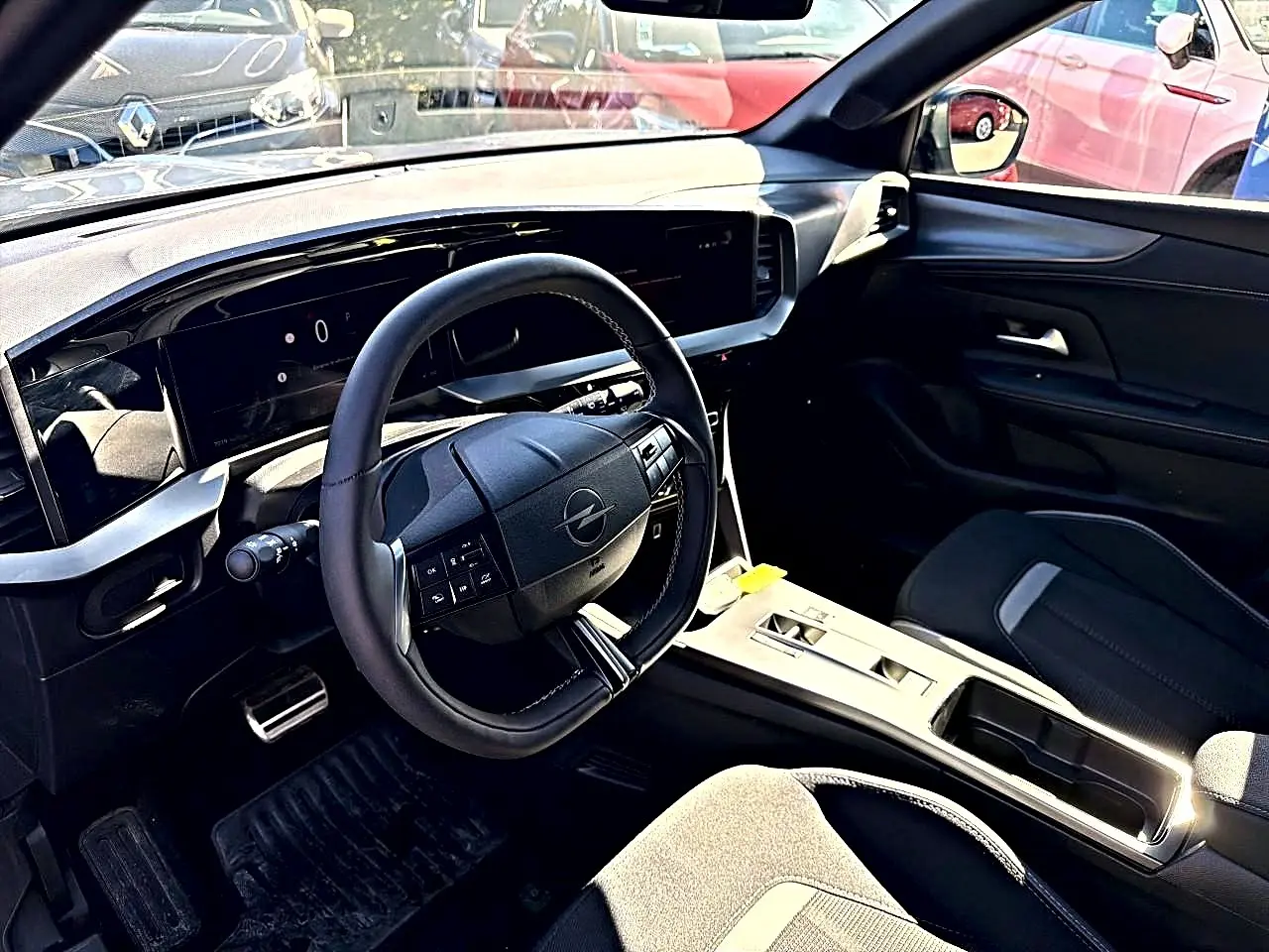Vue intérieure côté conducteur de l'Opel Mokka Electric gris 2025, volant multifonction et tableau de bord numérique.