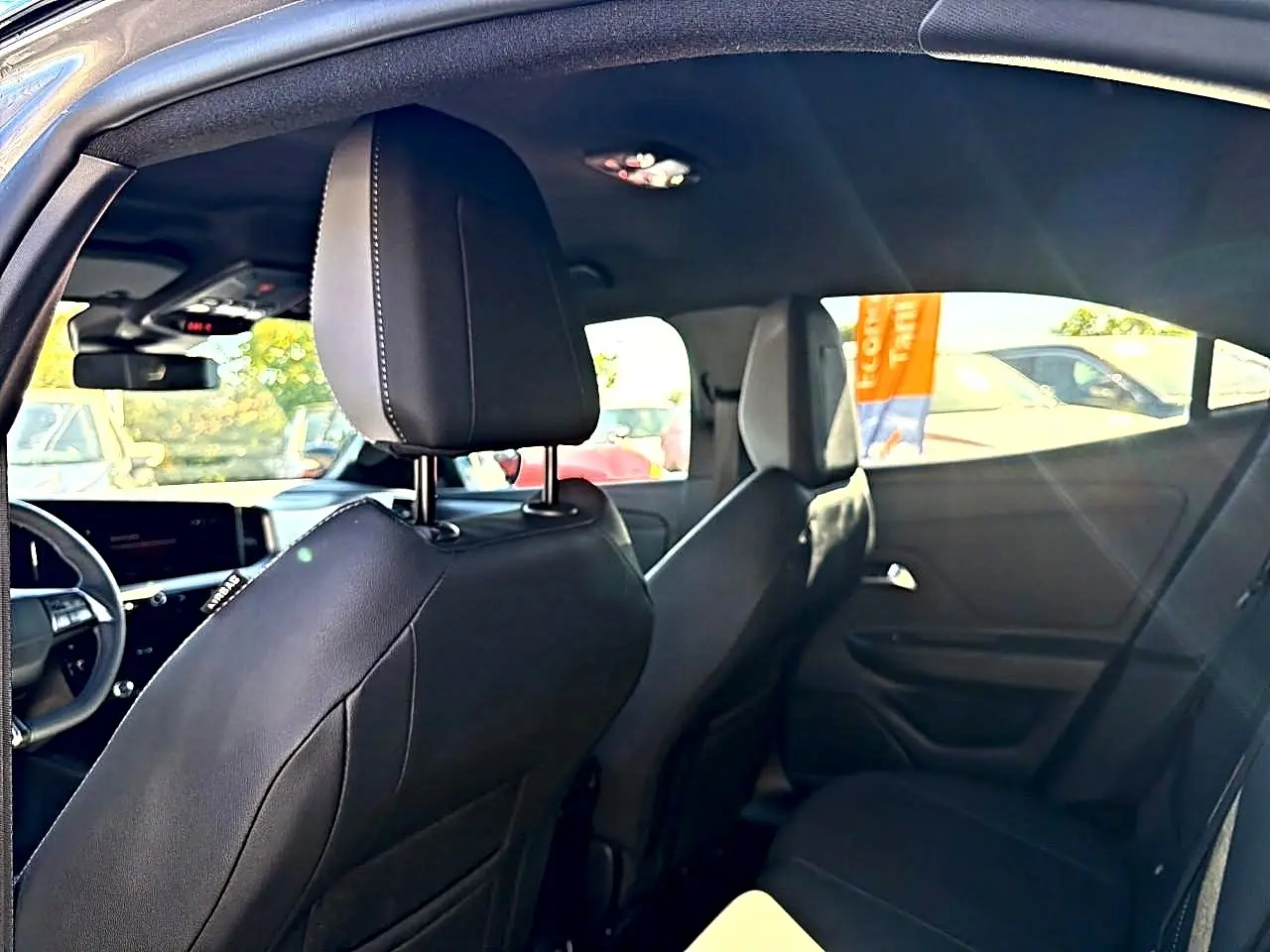 Vue intérieure arrière droite de l’Opel Mokka Electric 156 GS 2025 avec sièges noirs et tableau de bord partiellement visible.