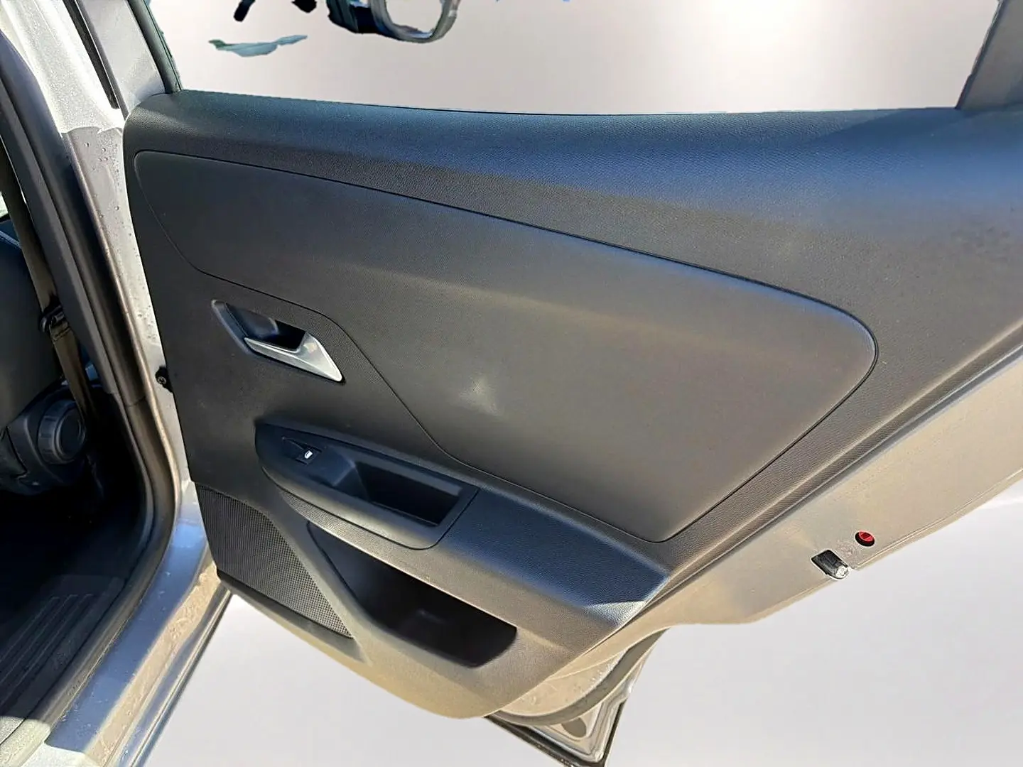 Vue rapprochée de la porte arrière gauche grise de l’Opel Mokka Electric 156 gs avec poignée et commande de vitre.