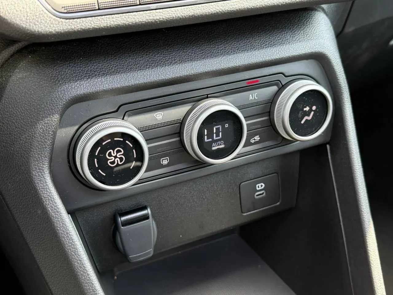 Gros plan sur les commandes de climatisation automatique de la Dacia Sandero Stepway Vert Cèdre 2025.