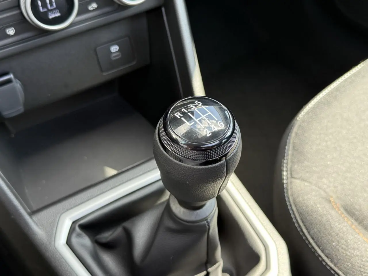 Gros plan sur le levier de vitesses manuel noir de la Dacia Sandero Stepway 2025, intérieur gris et noir.