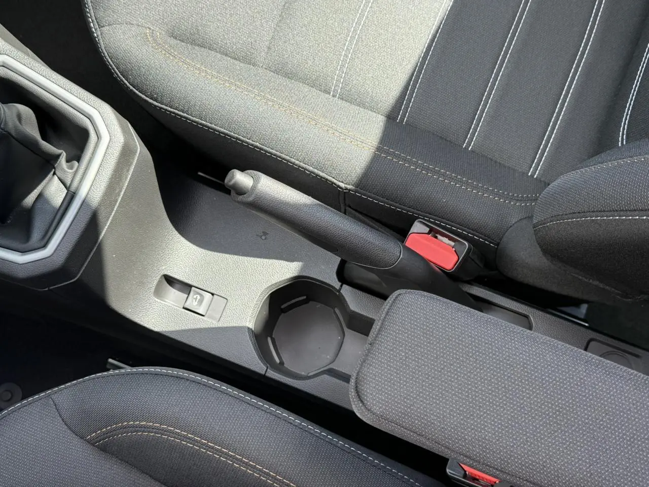 Vue rapprochée de la console centrale et frein à main de la Dacia Sandero Stepway 2025 avec sellerie noire et surpiqûres contrastées.