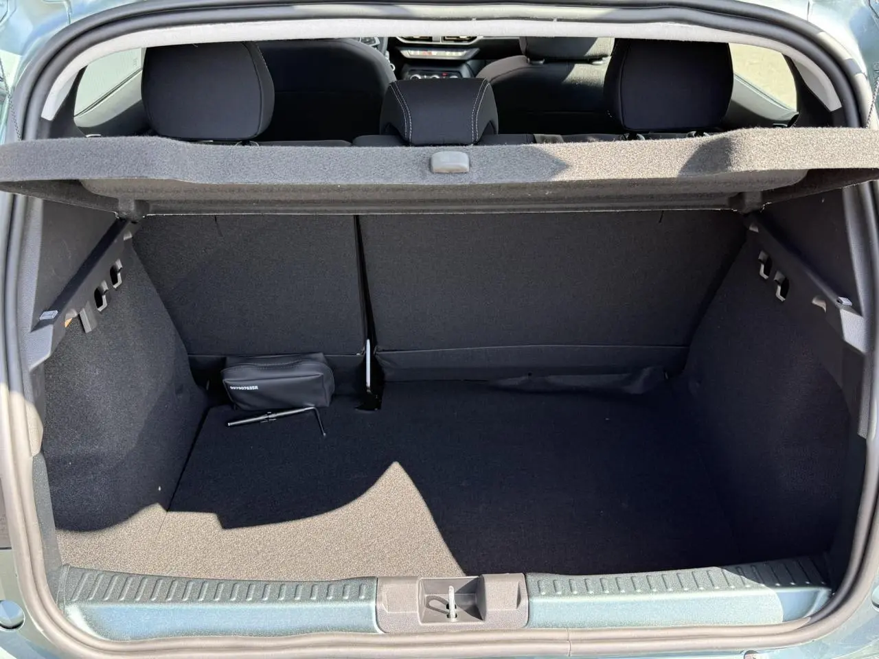 Coffre ouvert d'une Dacia Sandero Stepway Vert Cèdre, montrant l'espace de chargement et la tablette arrière.