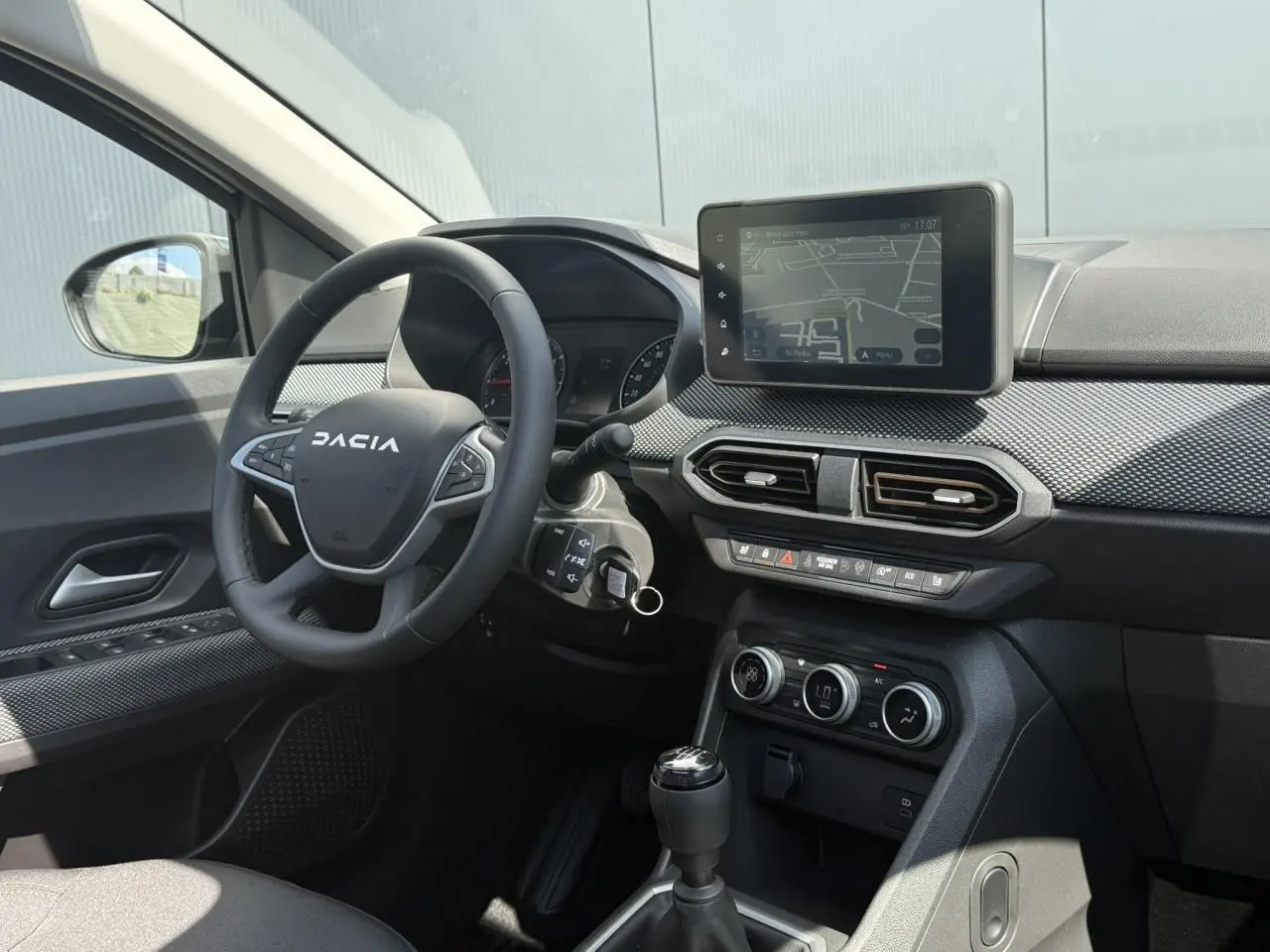Vue intérieure côté conducteur du tableau de bord et volant Dacia Sandero Stepway 2025 avec écran tactile et commandes intégrées.