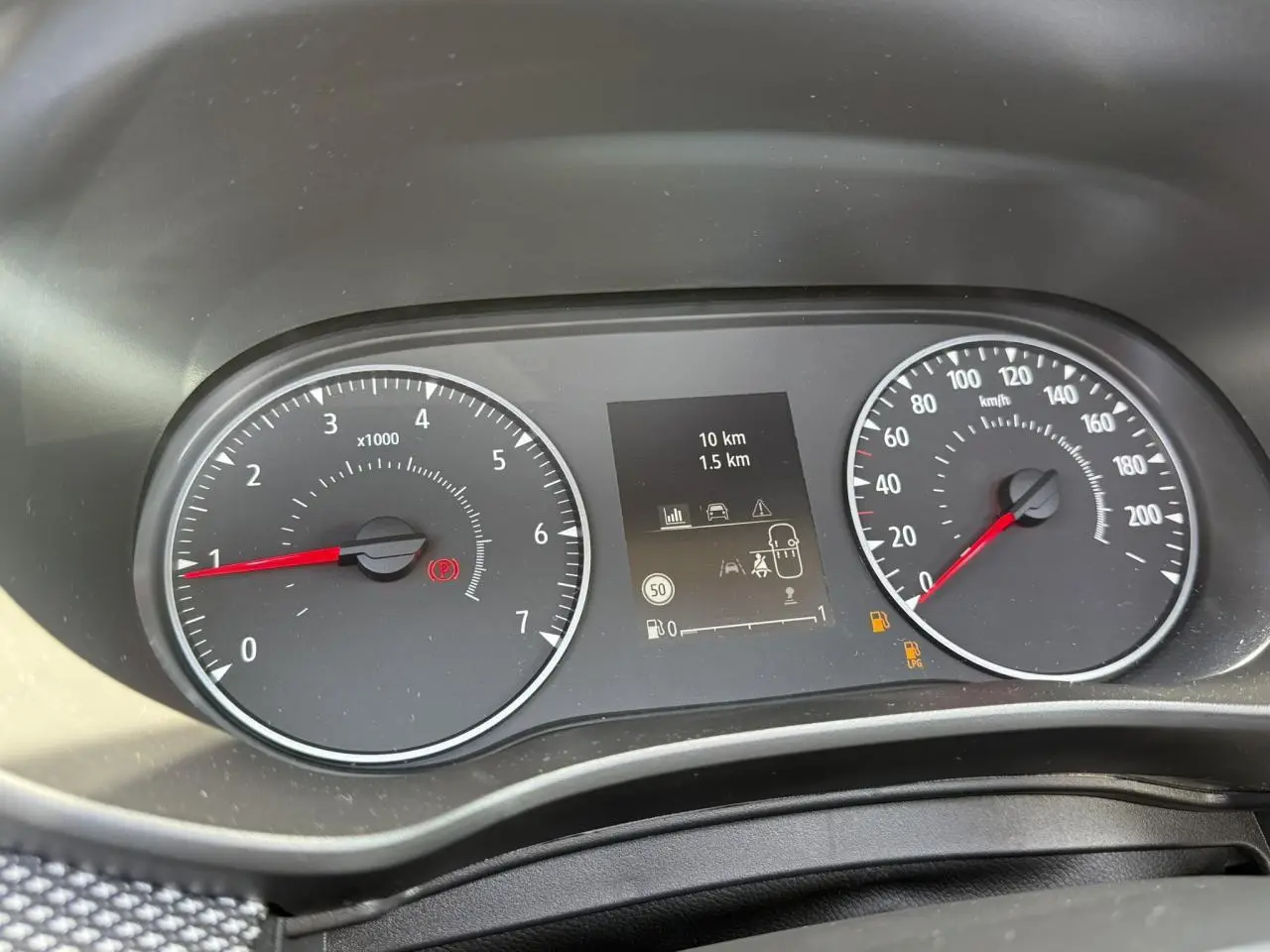 Vue rapprochée du tableau de bord numérique de la Dacia Sandero Stepway 2025 avec compteurs analogiques et indicateurs lumineux.