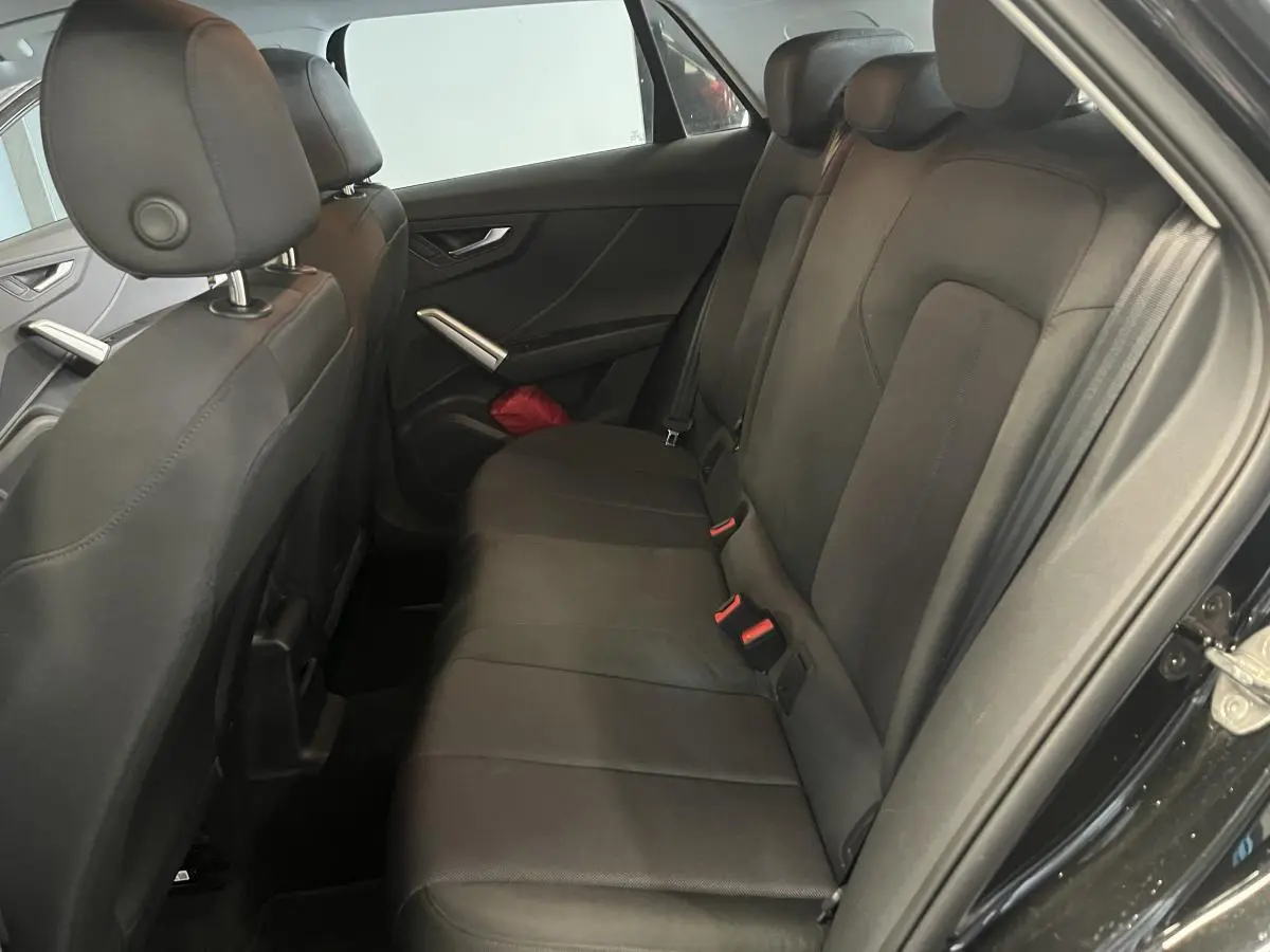 Vue intérieure côté droit des sièges arrière noirs en tissu de l'Audi Q2 2023 finition Design.