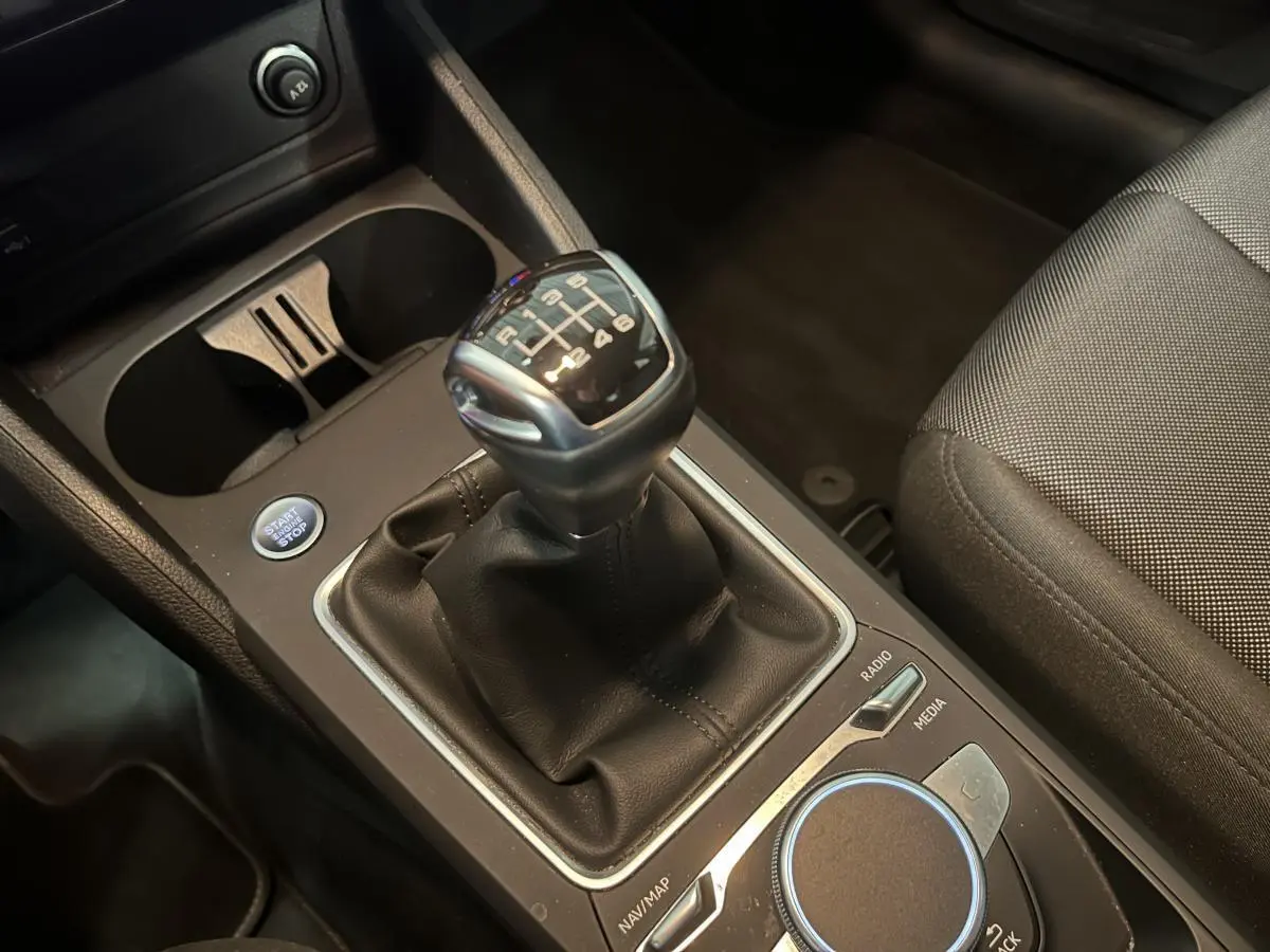 Gros plan sur la boîte manuelle noire et la console centrale de l'Audi Q2 1.0 30 TFSI Design 2023.