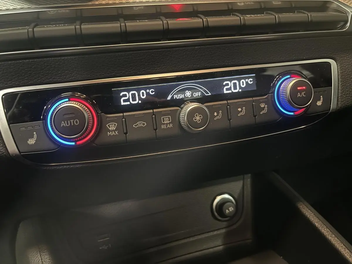 Vue rapprochée de la console centrale de l'Audi Q2 2023, affichant la climatisation automatique à 20°C.