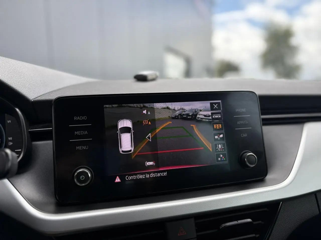 Écran tactile central affichant la caméra de recul du Skoda Kamiq Rouge Velvet, vue intérieure du tableau de bord.