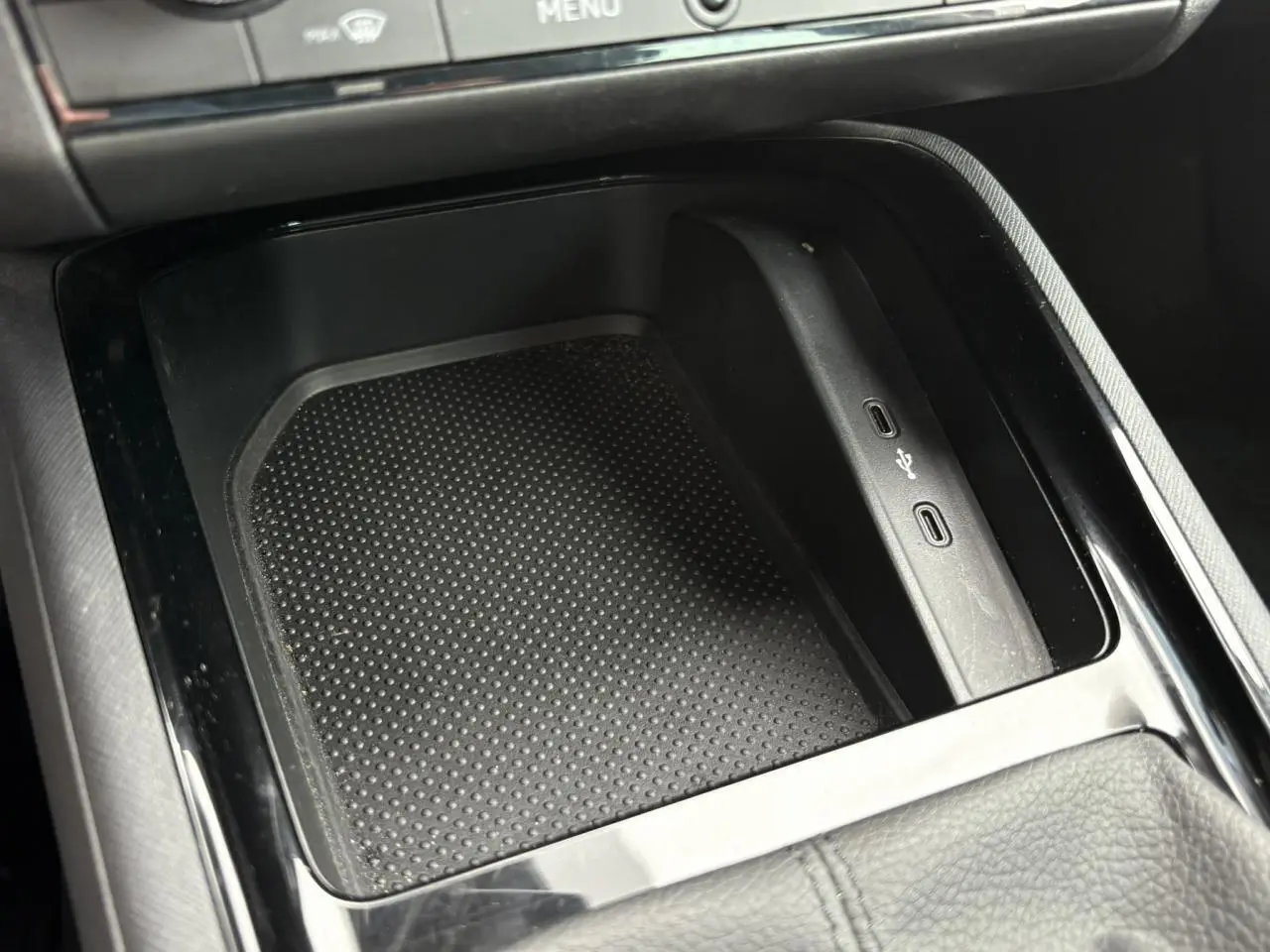 Gros plan sur la console centrale noire du Skoda Kamiq 2024 avec ports USB-C intégrés et surface antidérapante.