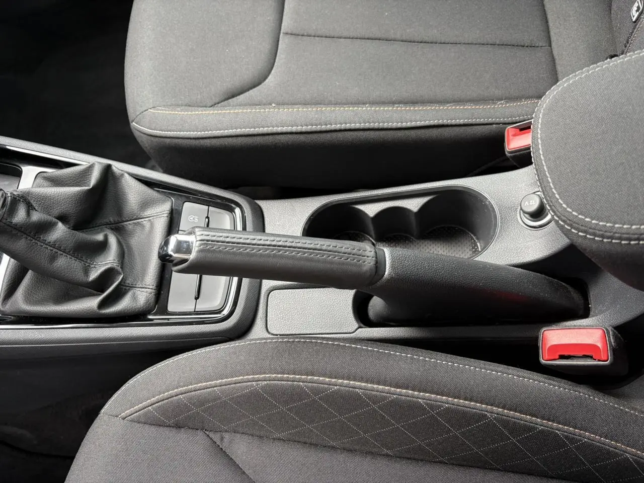 Vue rapprochée de la console centrale avec frein à main et accoudoir en tissu noir du Skoda Kamiq 2024.