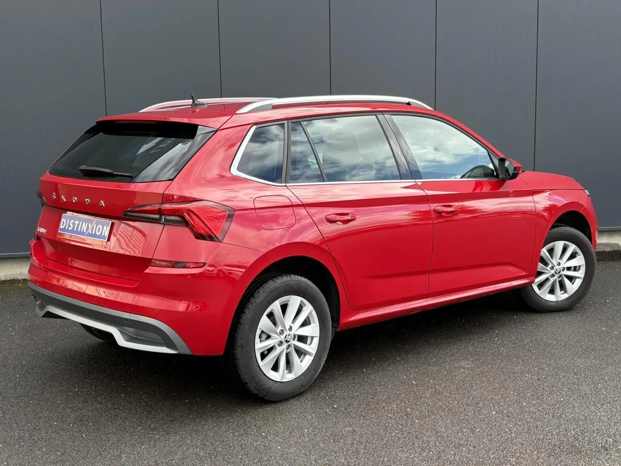 Vue 3/4 arrière droite d'un Skoda Kamiq rouge Velvet avec jantes alliage 16 pouces et vitres arrière surteintées.