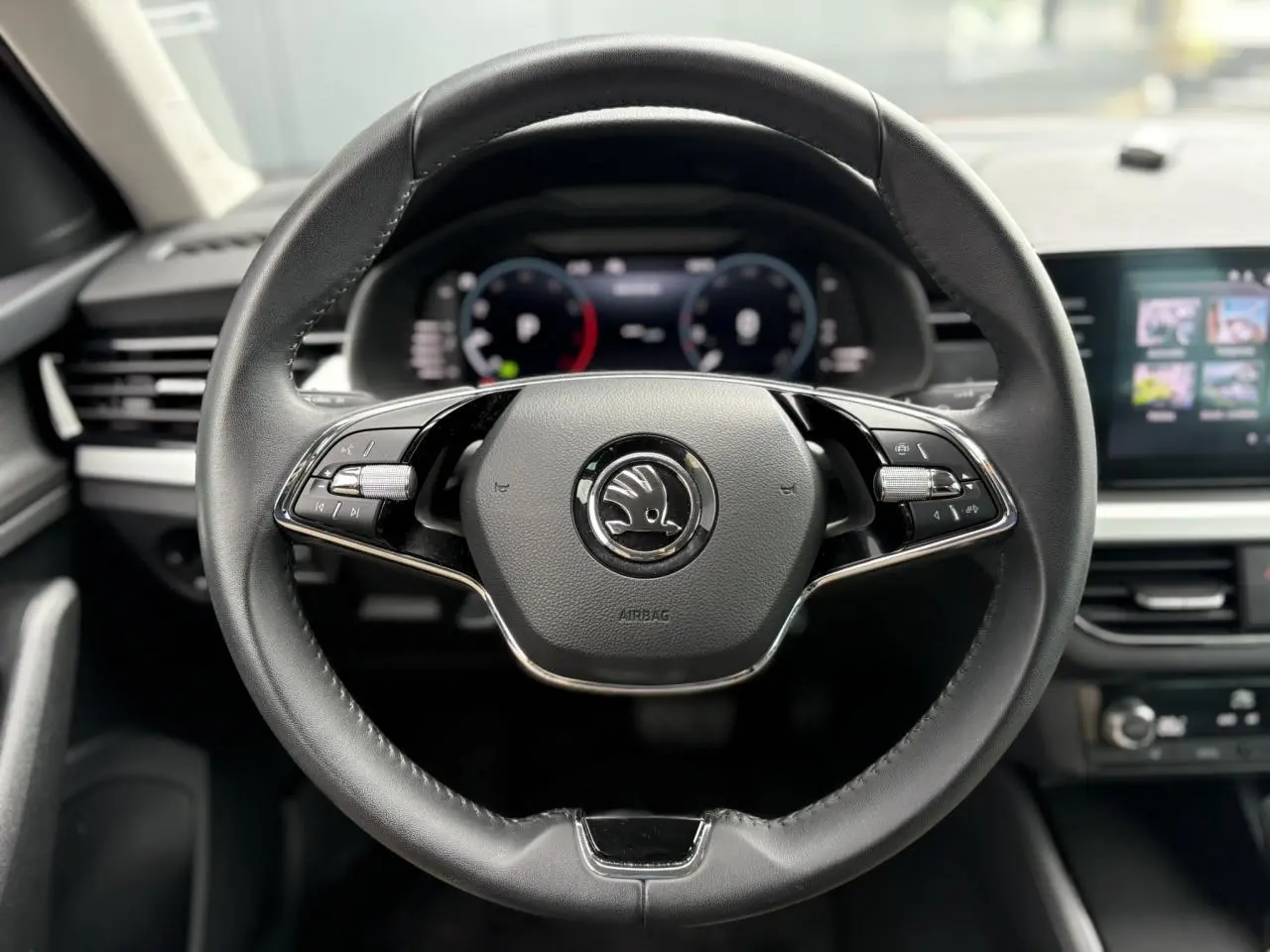 Vue rapprochée du volant cuir multifonctions de la Skoda Kamiq 2024 avec Digital Cockpit en arrière-plan.