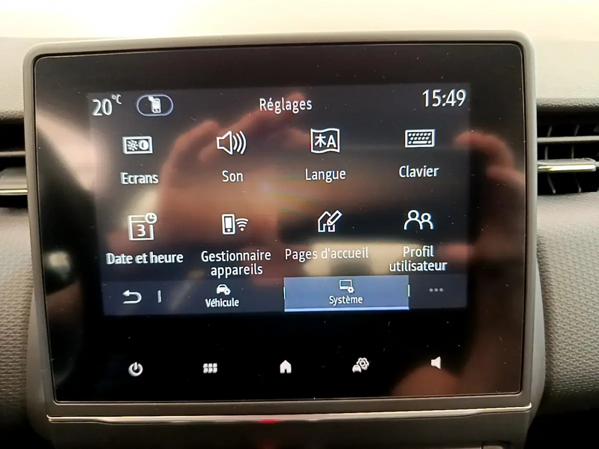 Écran tactile central affichant les réglages du système dans une Renault Clio Business TCe 100 gris clair, vue frontale intérieure.