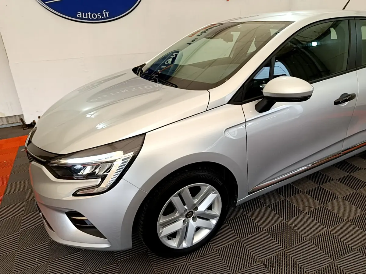 Renault Clio Business TCe 100 gris clair vue 3/4 avant droit, avec phares LED et jantes alliage visibles.