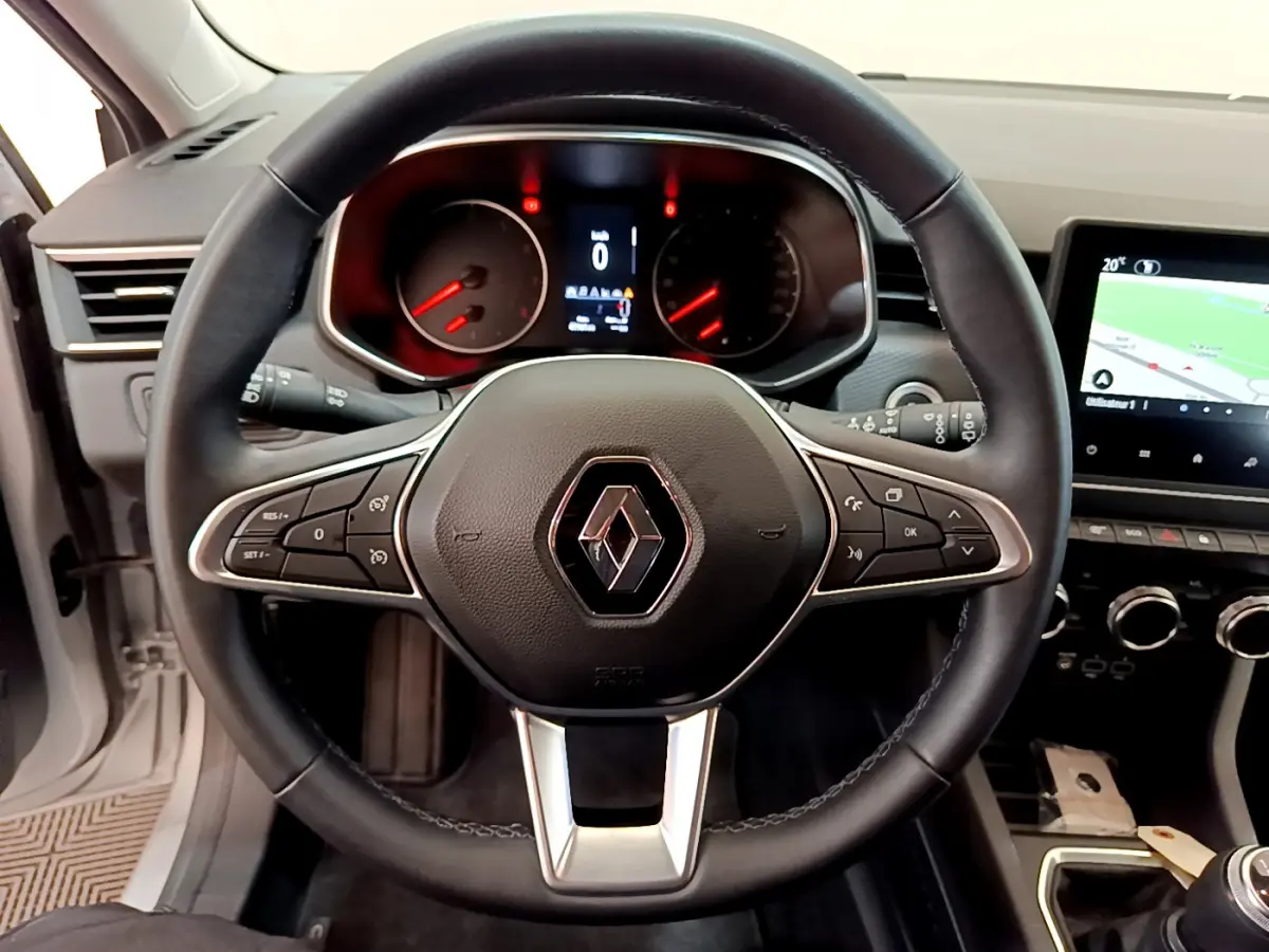 Vue rapprochée du volant cuir noir de la Renault Clio Business TCe 100 2020 avec tableau de bord et écran tactile visible.