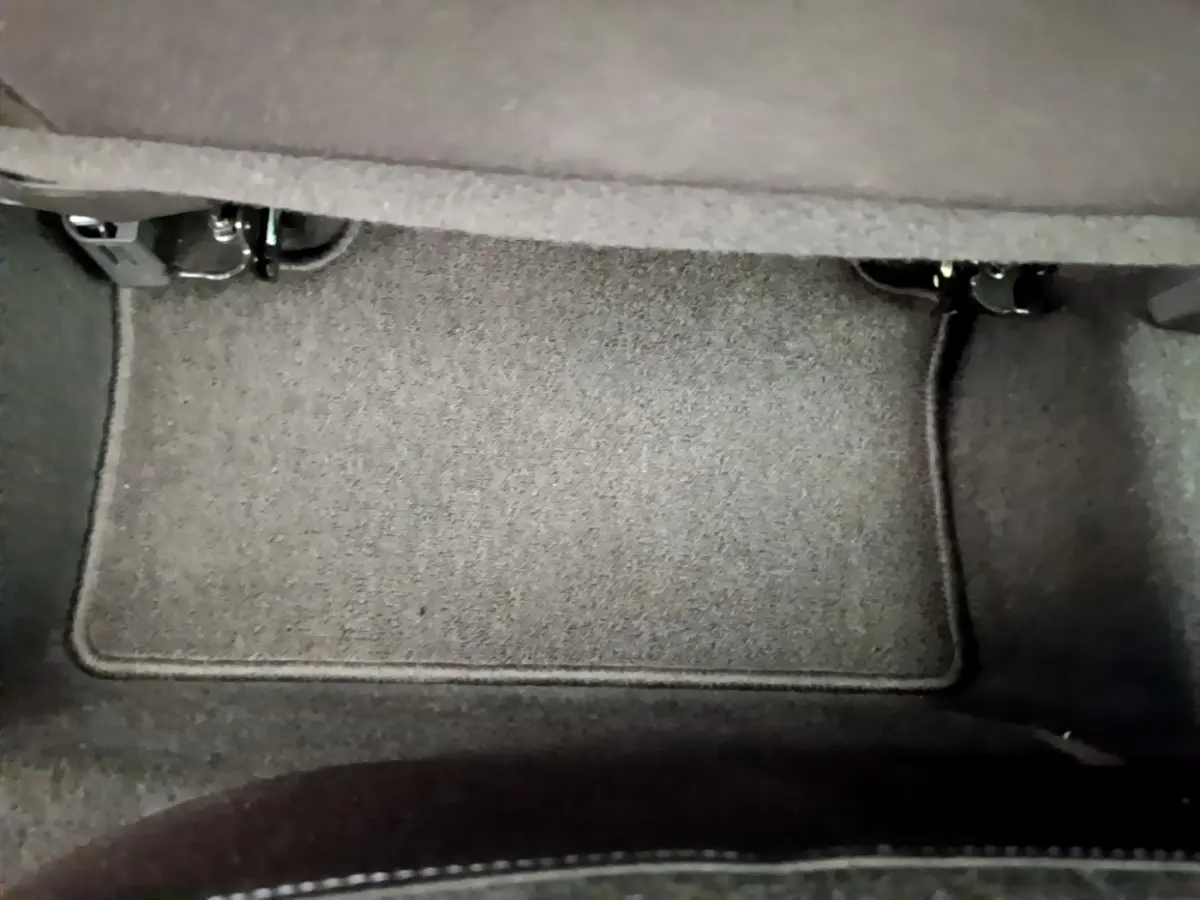 Tapis de sol gris foncé sous le siège arrière d'une Renault Clio Business TCe 100 de 2020.