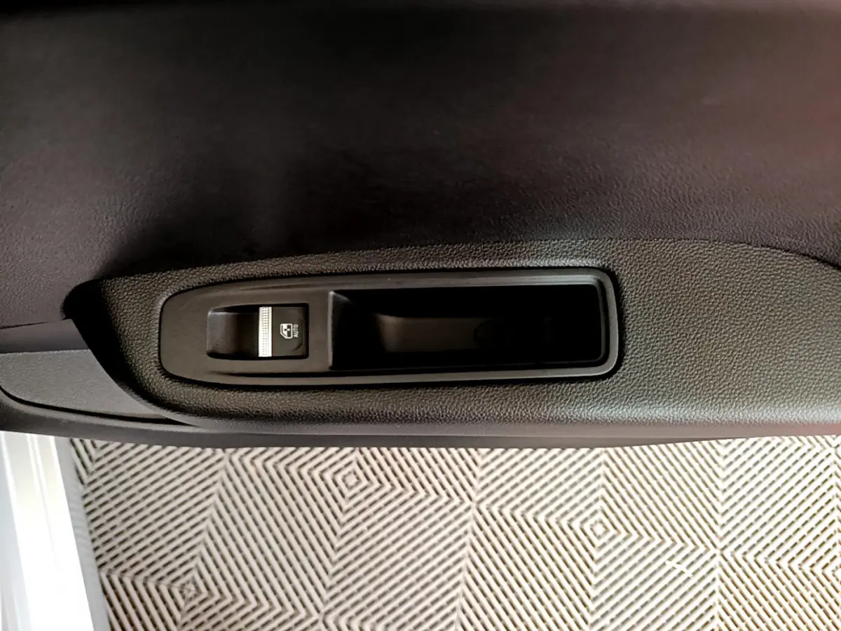 Bouton de commande de lève-vitre côté conducteur sur la porte intérieure noire d'une Renault Clio Business gris clair 2020.