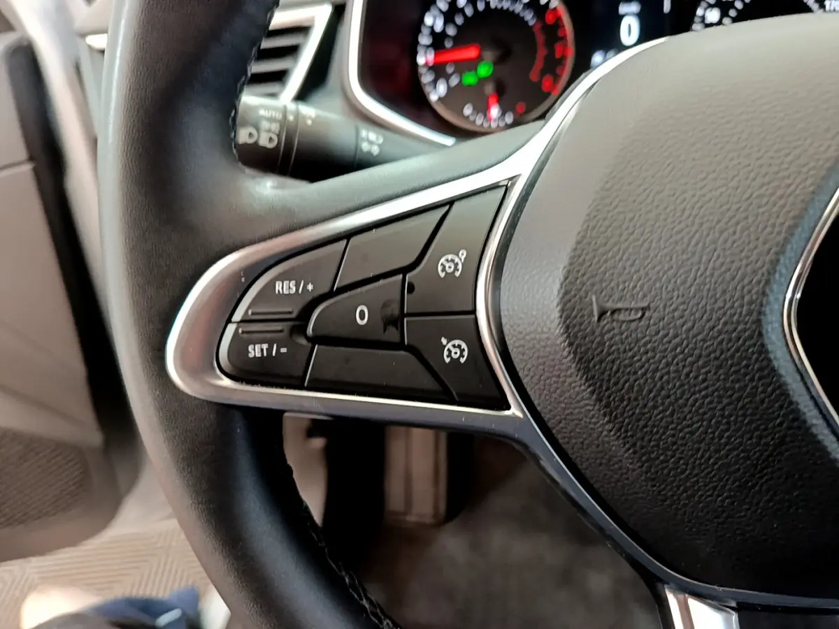 Gros plan sur le volant cuir noir de la Renault Clio Business 2020, avec commandes de régulateur de vitesse visibles.