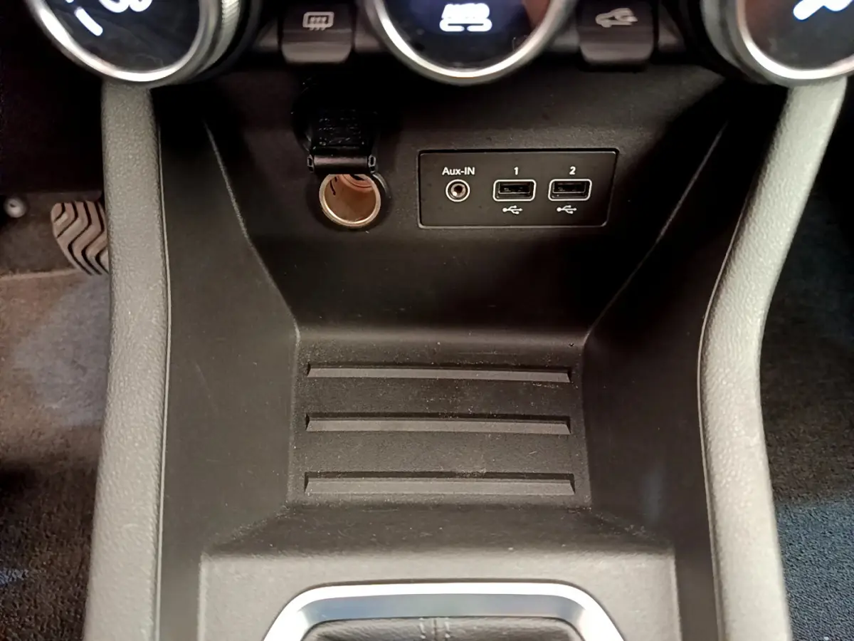Vue rapprochée de la console centrale noire de la Renault Clio Business TCe 100 avec prises USB et prise auxiliaire.