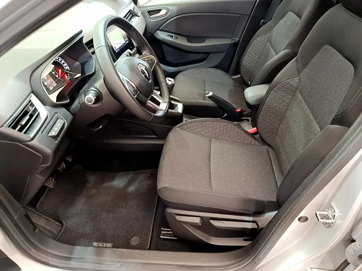 Intérieur avant droit d'une Renault Clio Business TCe 100 2020 gris clair, sièges tissu et tableau de bord avec écran tactile.