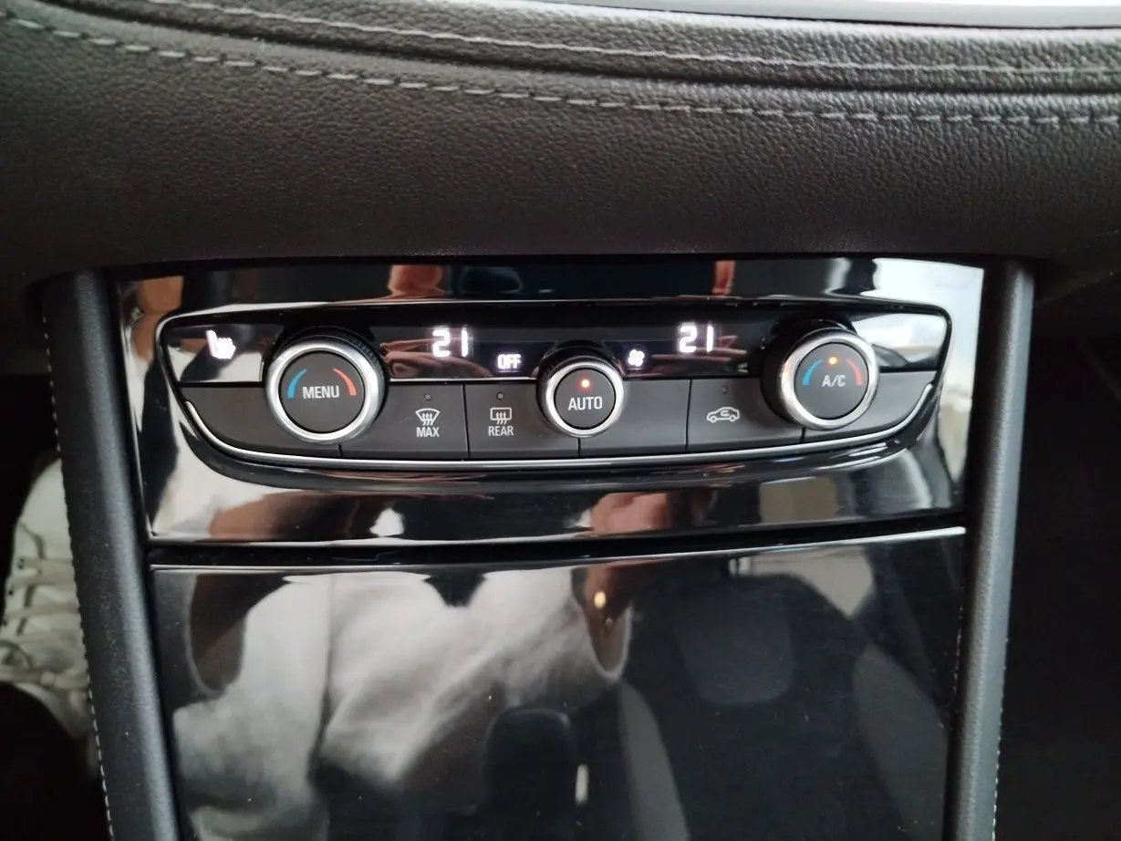 Panneau de commande de la climatisation automatique de l’Opel Grandland X 1.5 CDTI, avec affichage digital et finition noire brillante.