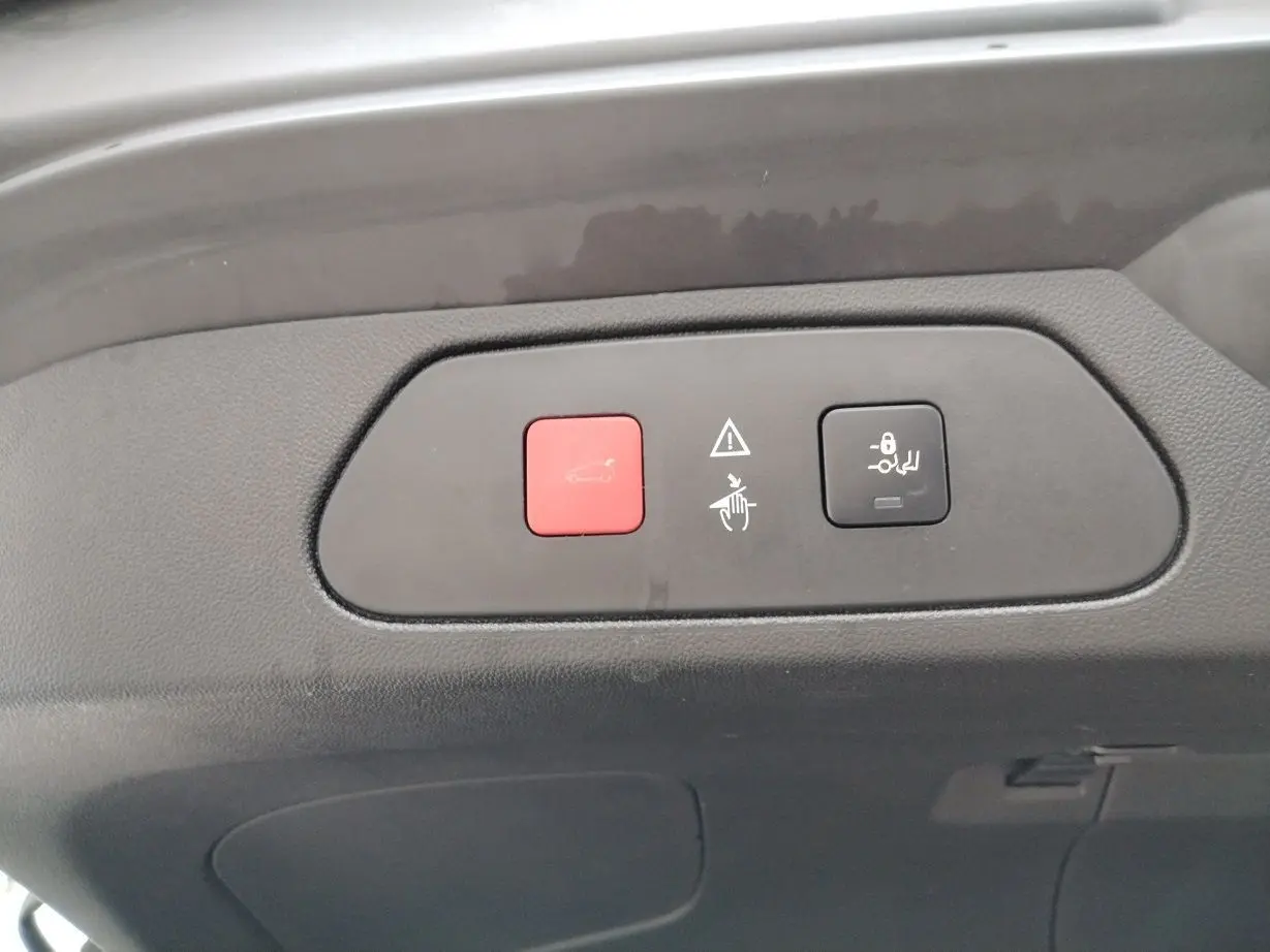 Boutons rouge et noir pour ouverture et verrouillage du coffre sur le hayon intérieur d'un Opel Grandland X gris platinium.