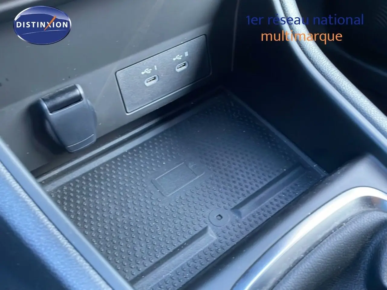 Gros plan sur la console centrale noire du Renault Captur 2025, avec ports USB-C et espace de rangement antidérapant.