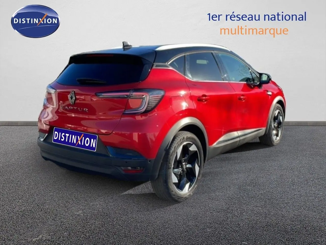 Vue 3/4 arrière droite du Renault Captur rouge Désir Métal avec toit noir et jantes noires contrastées.