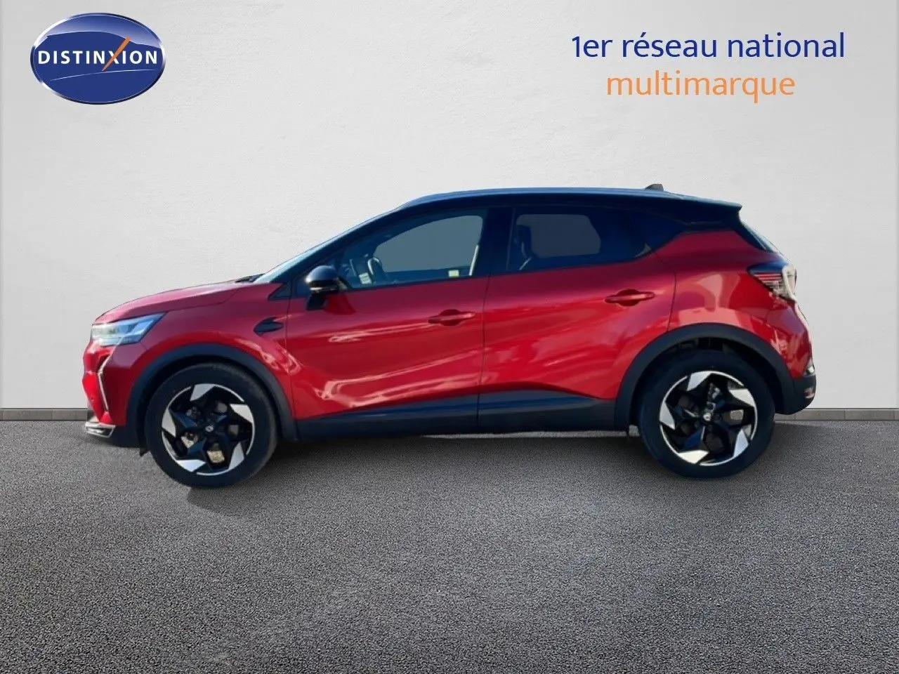 Vue de profil côté gauche du Renault Captur 2025 rouge Désir métal avec toit noir et jantes bicolores.