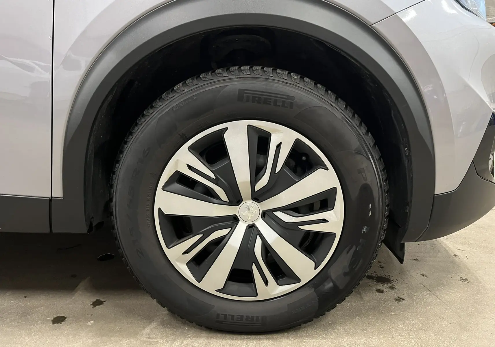 Gros plan sur la roue avant gauche d’un Peugeot 2008 gris alu, avec jante alliage au design moderne et pneu Pirelli.