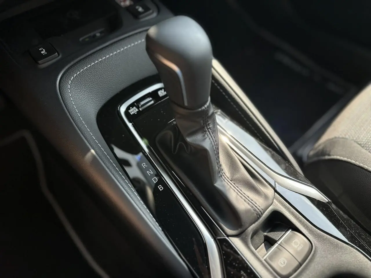 Le levier de vitesse automatique noir de la Toyota Corolla Touring Sport 1.8 Hybrid 2025 vu en gros plan intérieur.