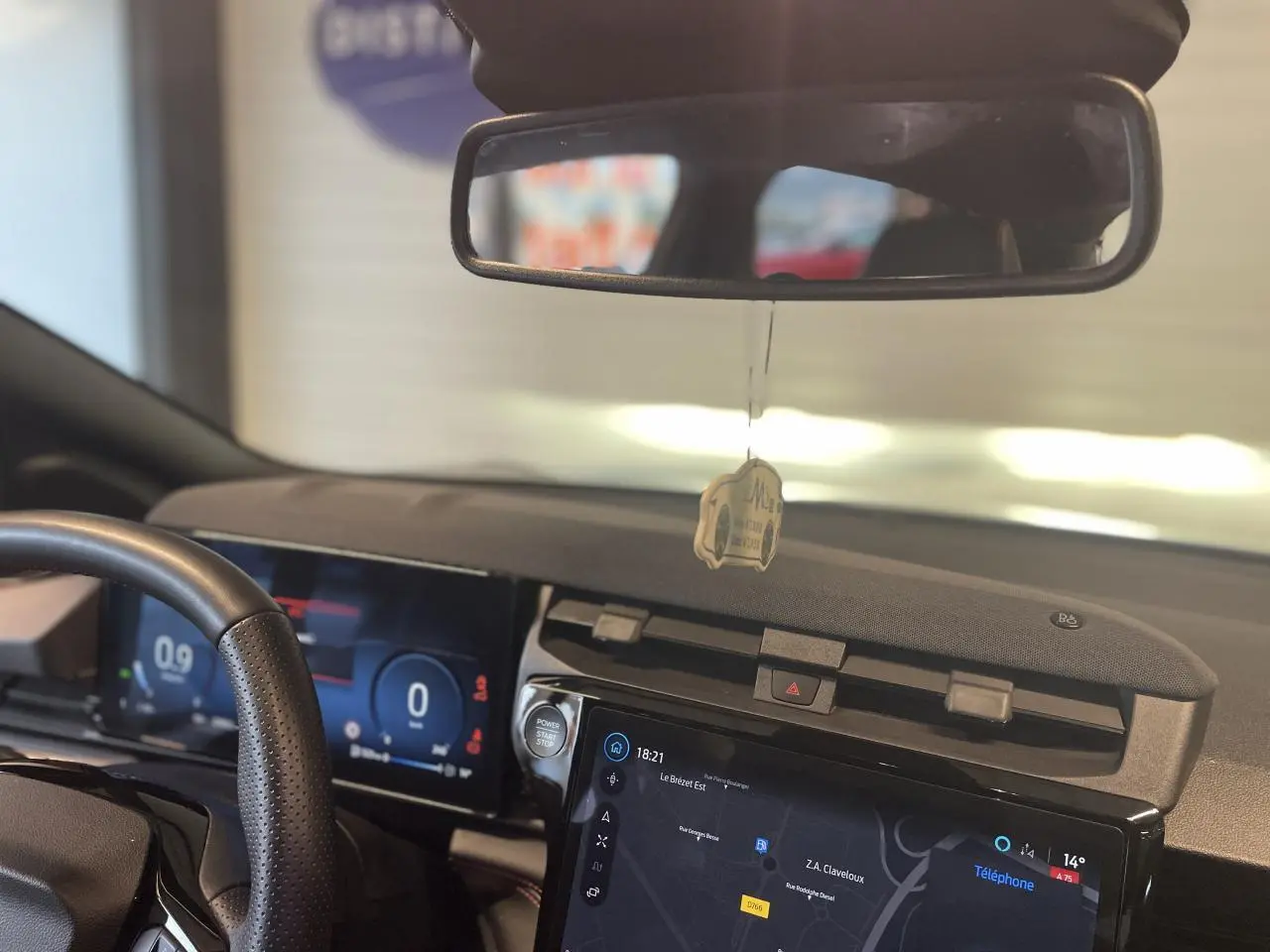 Vue intérieure du tableau de bord du Ford Puma gris clair, avec écran tactile central et volant partiellement visible.