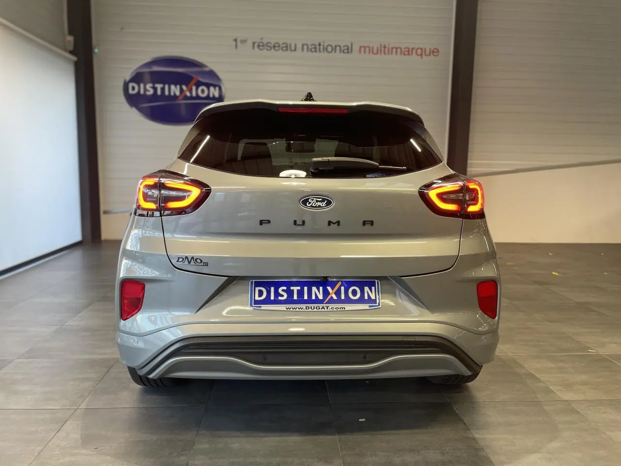 Vue arrière d'un Ford Puma gris clair 2024 avec feux LED allumés et logo distinctif sur porte de coffre.