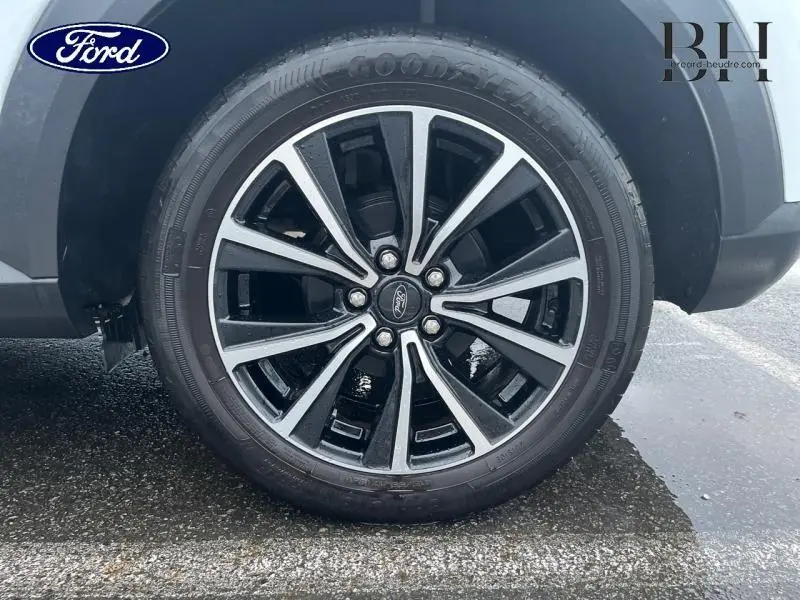 Gros plan sur la jante alu noire et argentée du Ford Puma blanc Glacier, vue côté droit arrière.